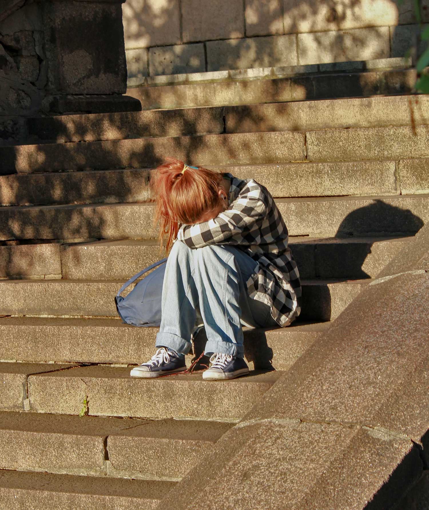 teen sitting on steps alone sad
